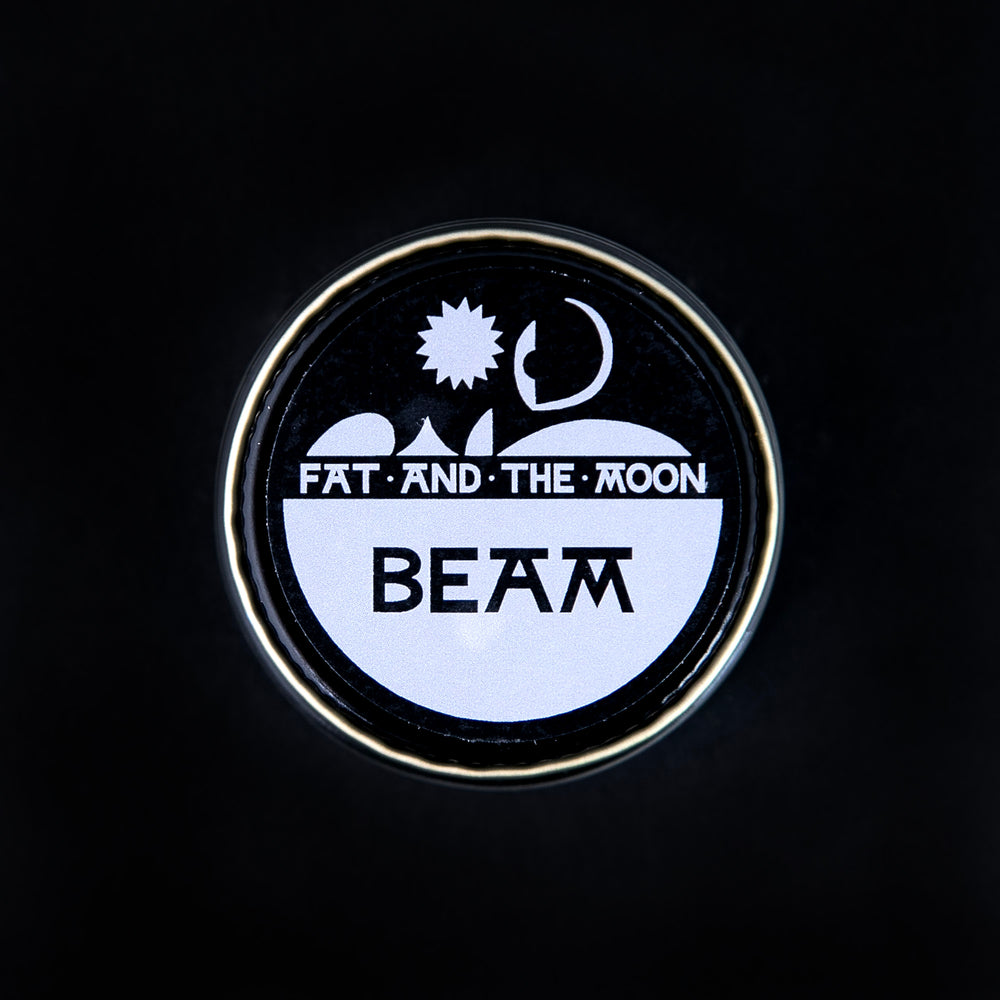 
                      
                        closed glass pot of Fat and the Moon's "Beam" highlighter seen from above on black background
                      
                    