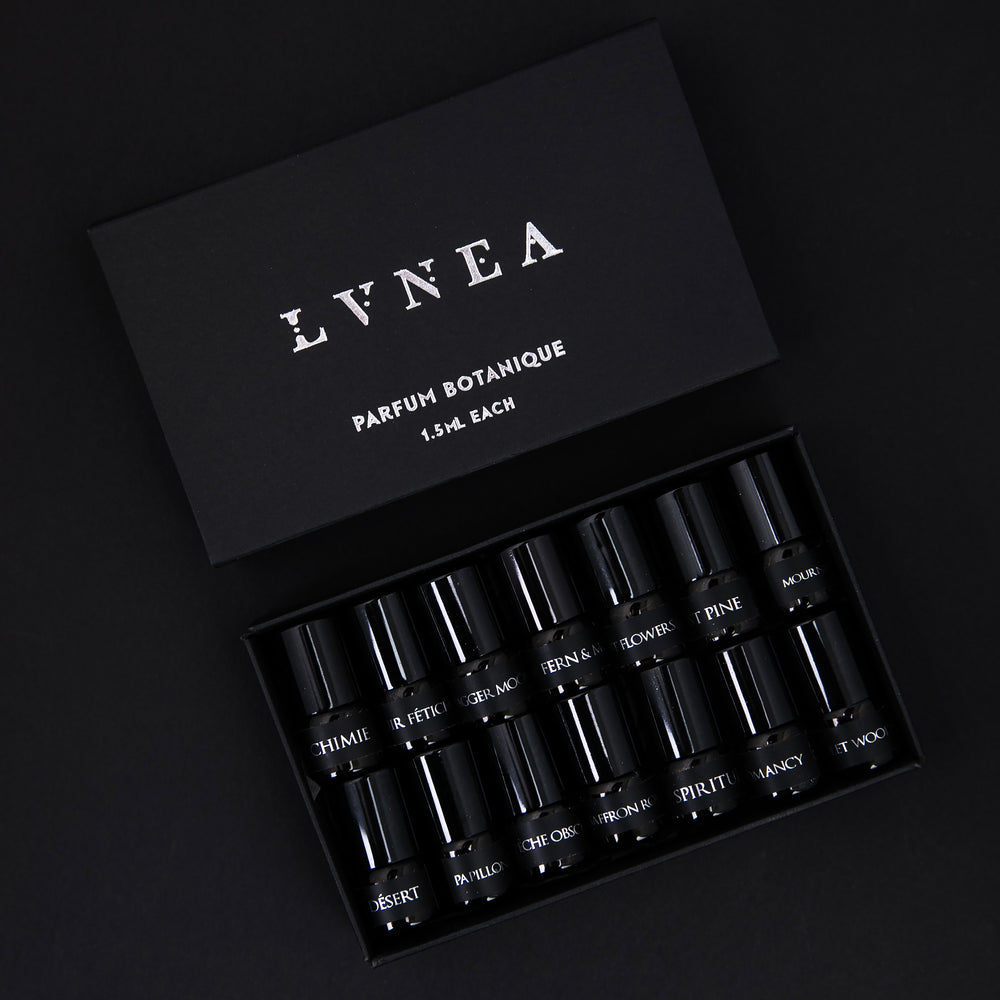 The full LVNEA parfum botanique sample set, presented in a black cardboard box. The lid is open, revealing all 14 sample vials of perfume neatly nestled together.