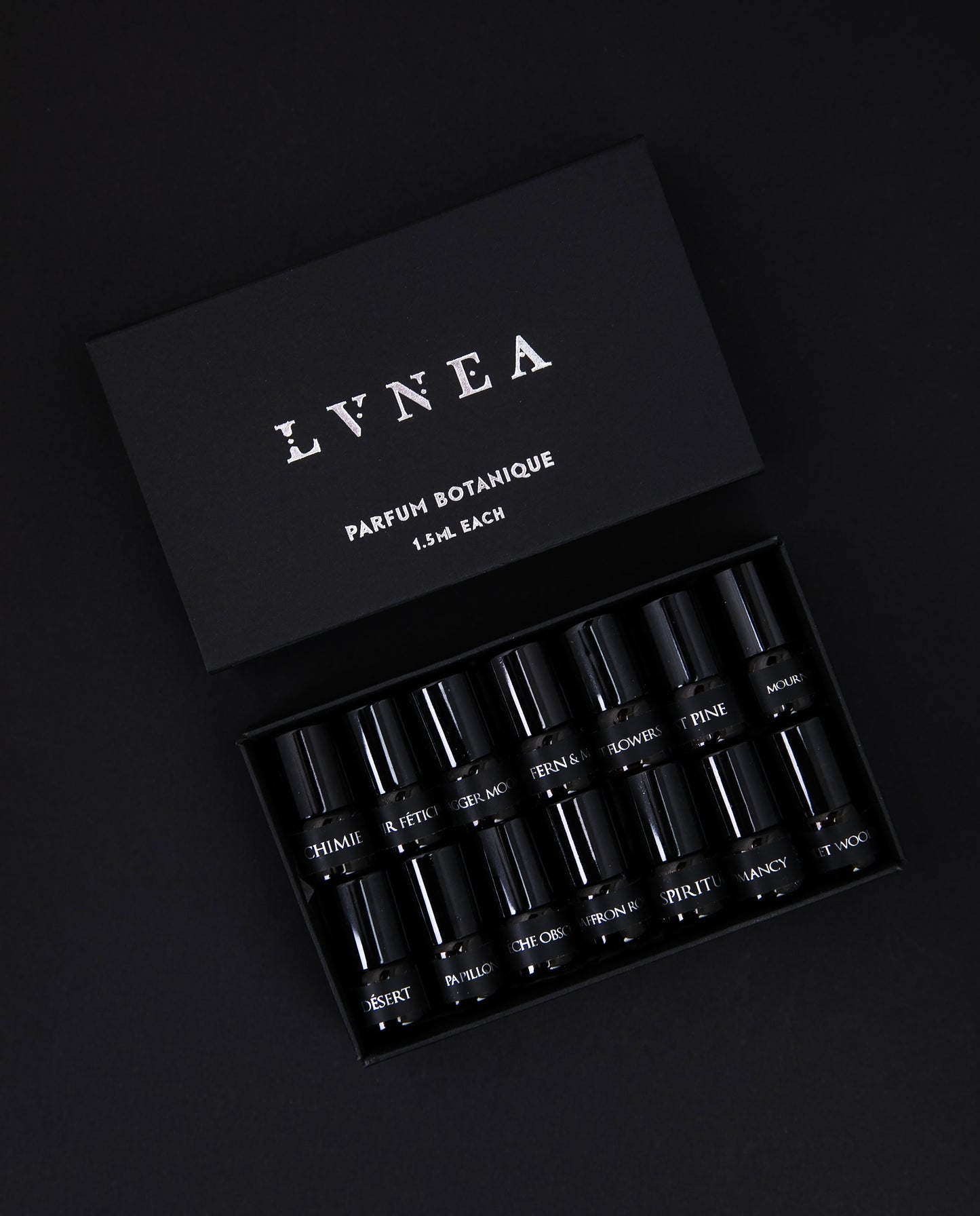 The full LVNEA parfum botanique sample set, presented in a black cardboard box. The lid is open, revealing all 14 sample vials of perfume neatly nestled together.