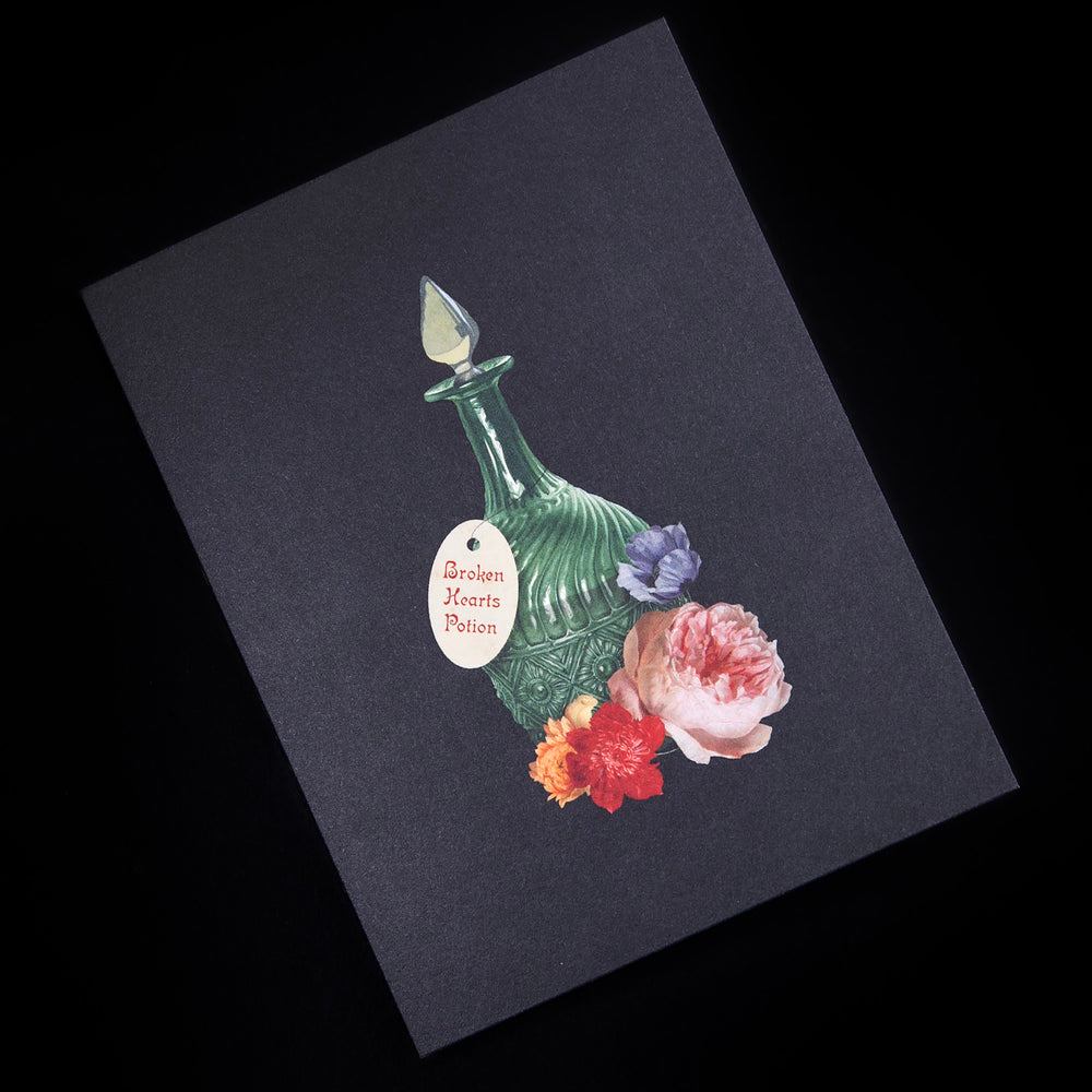 black greeting card with illustration of glass bottle surrounded by florals