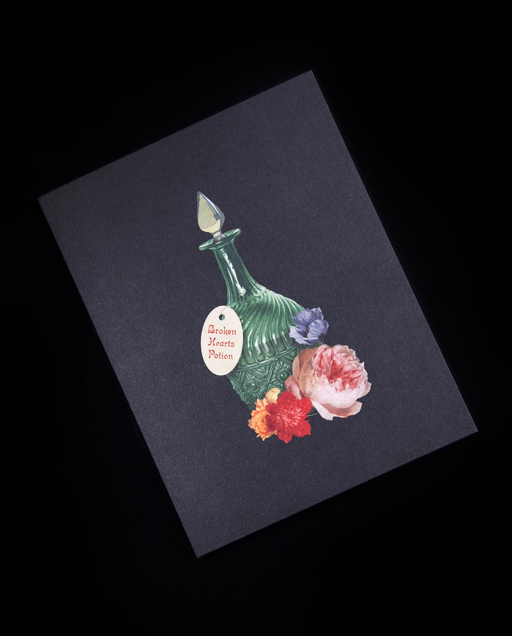 black greeting card with illustration of glass bottle surrounded by florals