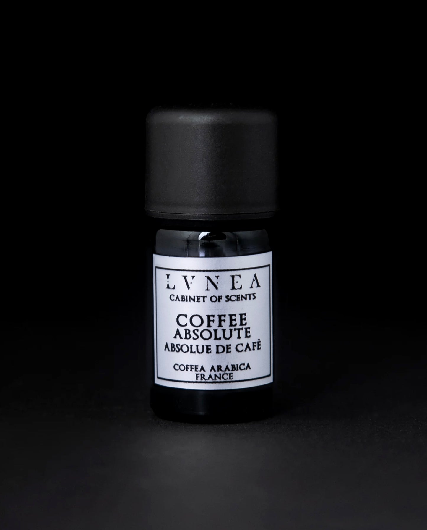 5ml black glass bottle of coffee absolute on a black background