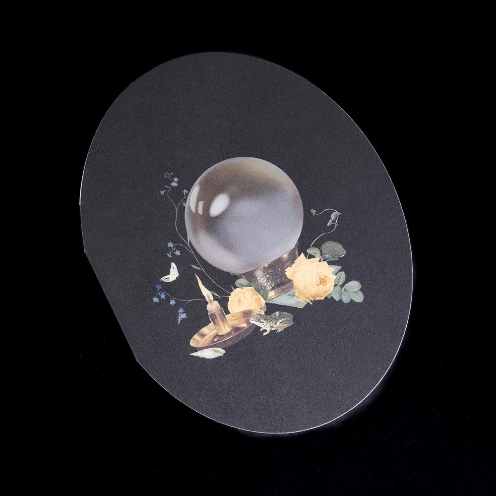 
                      
                        black oval shaped card with illustration of a crystal ball, seen against a black background
                      
                    