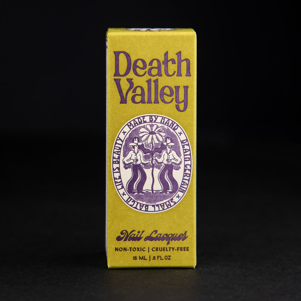 
                      
                        Death Valley Nails box against black background, the box is chartreuse coloured with vintage-inspired purple lettering and illustrations
                      
                    