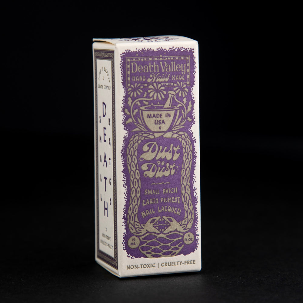 
                      
                        Box for "Dust to Dust" collection nail polishes. The box is cream-coloured with a purple vintage-style illustration of a mortar and pestle, and two snakes
                      
                    