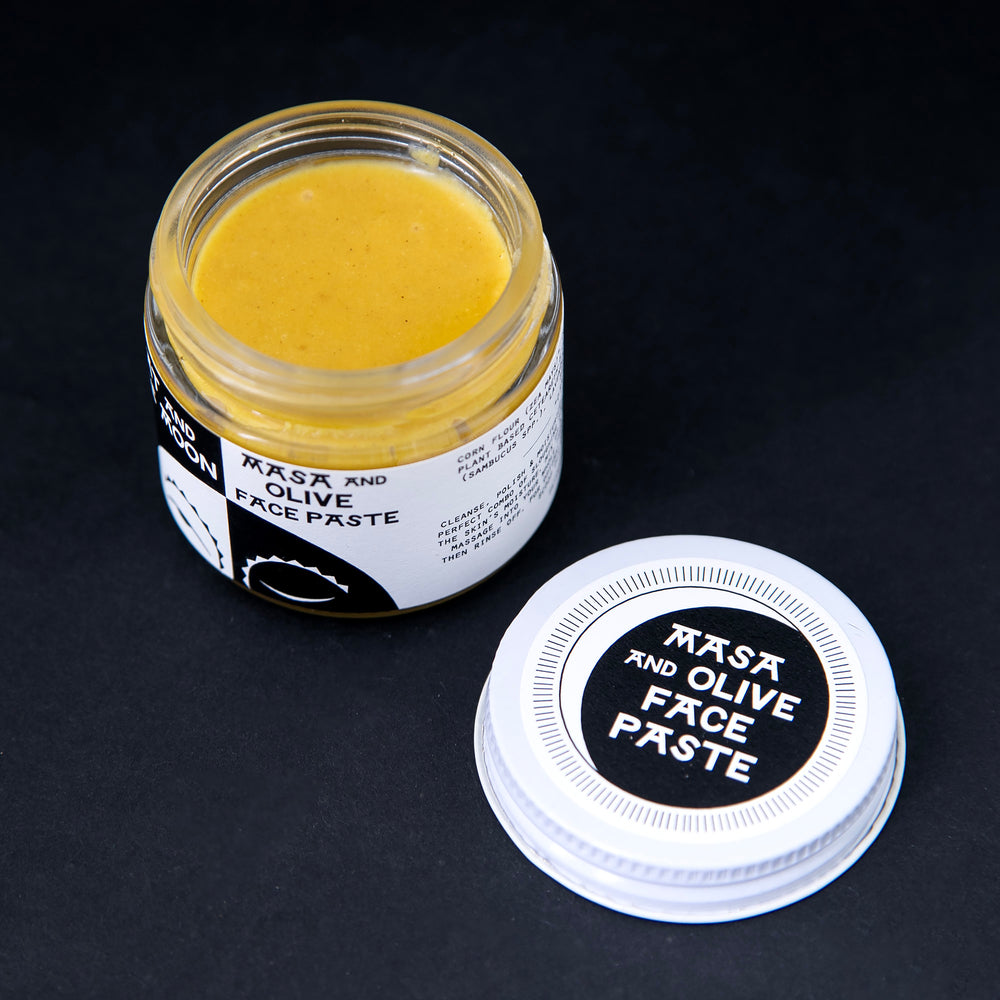 
                      
                        open glass jar of Fat and the Moon's "Masa and Olive Face Paste", revealing a golden yellow facial scrub product.
                      
                    