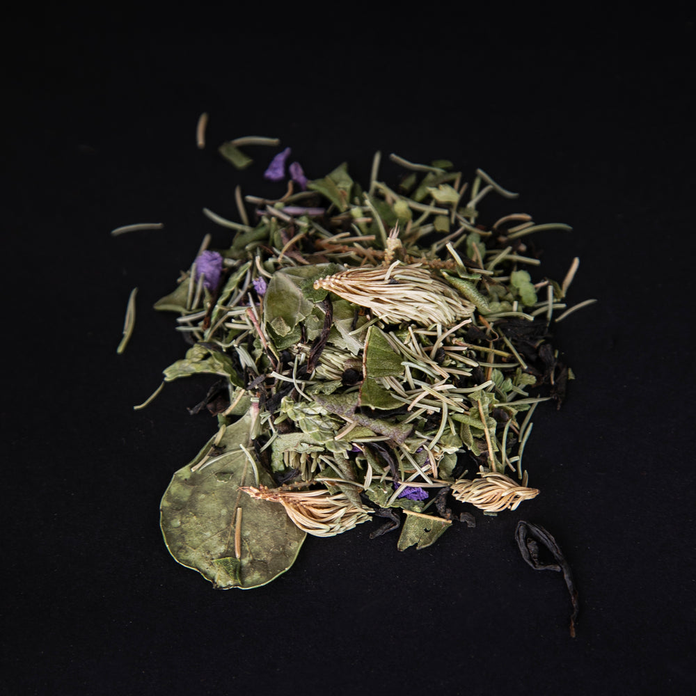 handful of l'Achillée's "Feu de forêt" tea on a black background