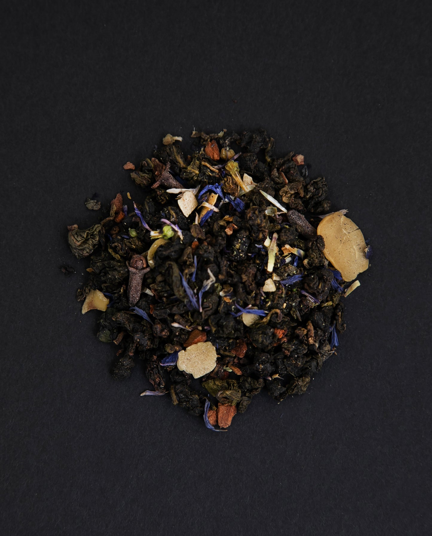 small pile of "flower moon" tea viewed from above against a black background