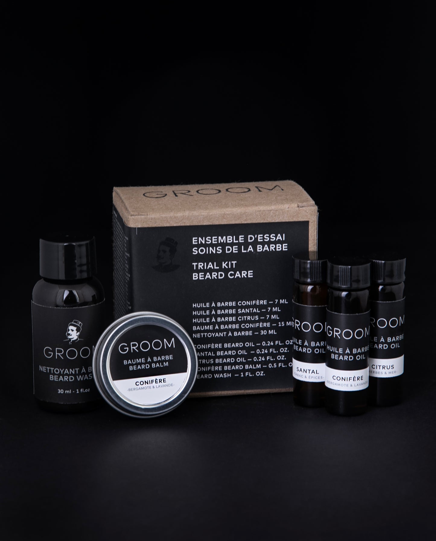 GROOM's "Beard Care Trial Kit" against a black background. The kit is composed of 3 beard oil samples in glass vials, one beard balm sample in a metal tin, and one beard wash sample in a small squeeze bottle, all enclosed in a cardboard box.