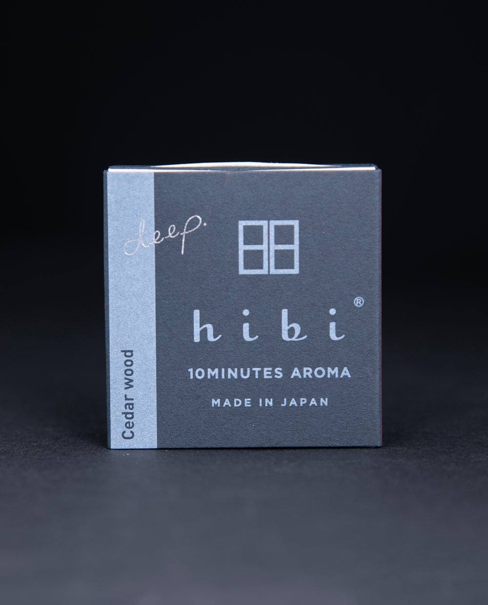 Dark slate grey paper box containing HIBI 