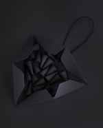 open black triangular incense box on black background