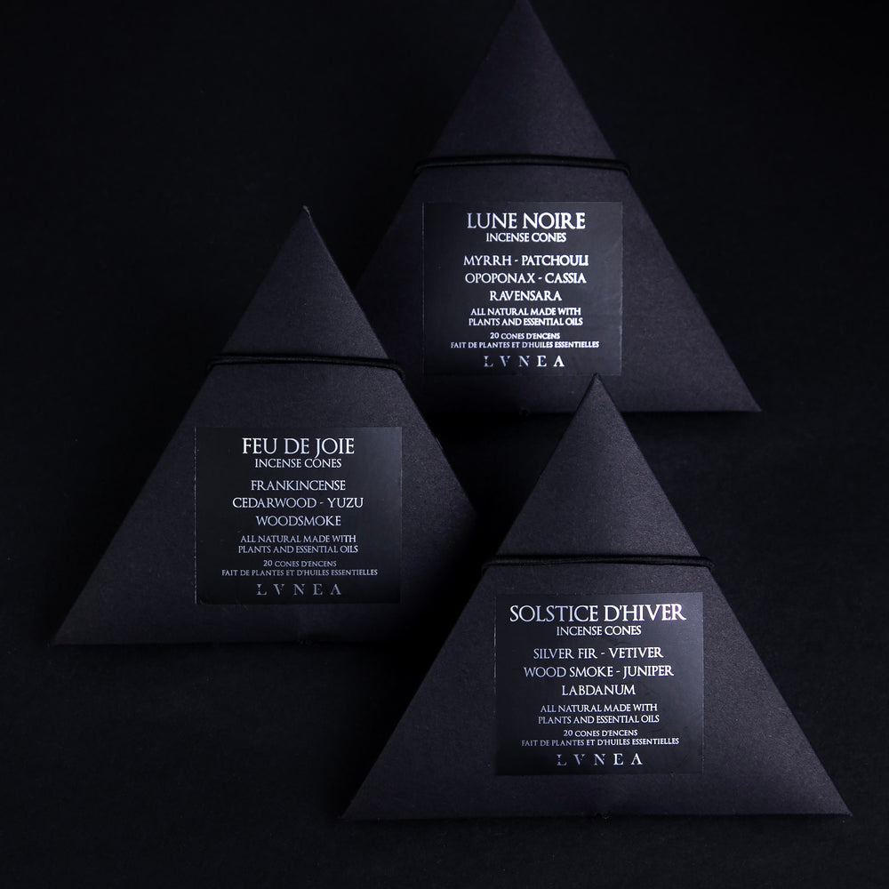 A set of three boxes of LVNEA incense cones. Each contains 20 cones housed in a recyclable black paper pyramid box with a black elastic closure. The labels are black with silver lettering each respectively describing the products as follows Solstice d'hiver features vetiver, woodsmoke, silver fir, labdanum, and juniper. Lune Noire myrrh, patchouli, opoponax, cassia and ravensara. Feu de joie features of frankincense, cedarwood, yuzu, and woodsmoke.