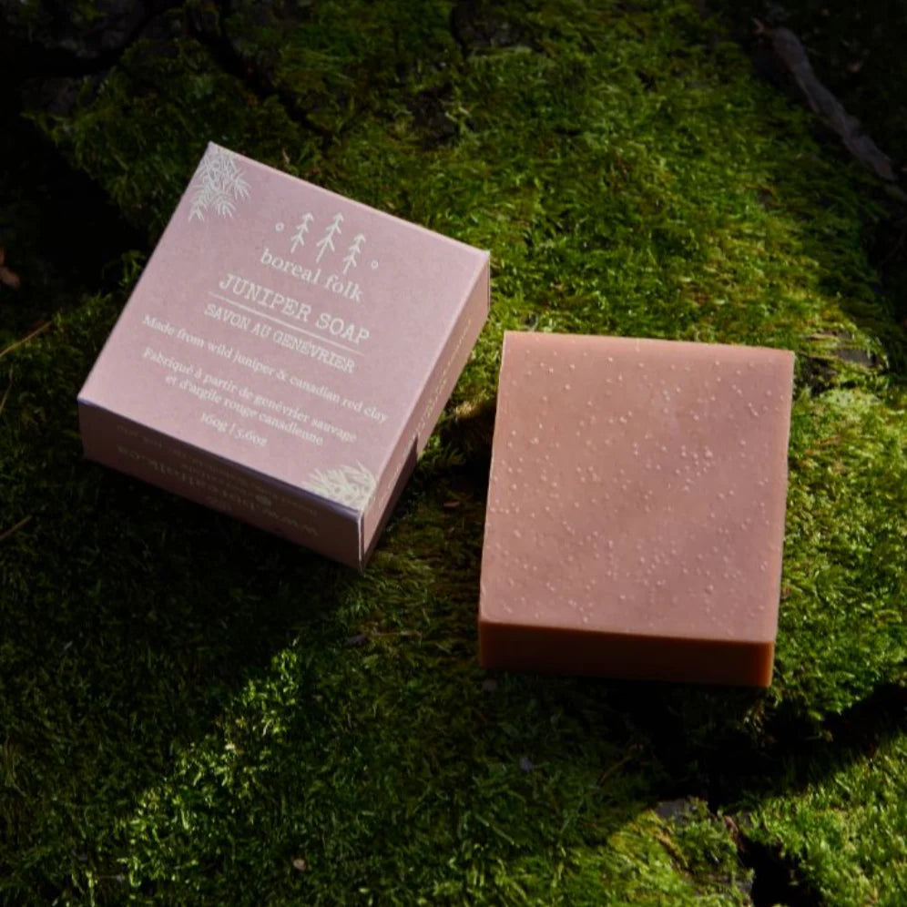 Box and bar of juniper soap sitting atop a bed of moss