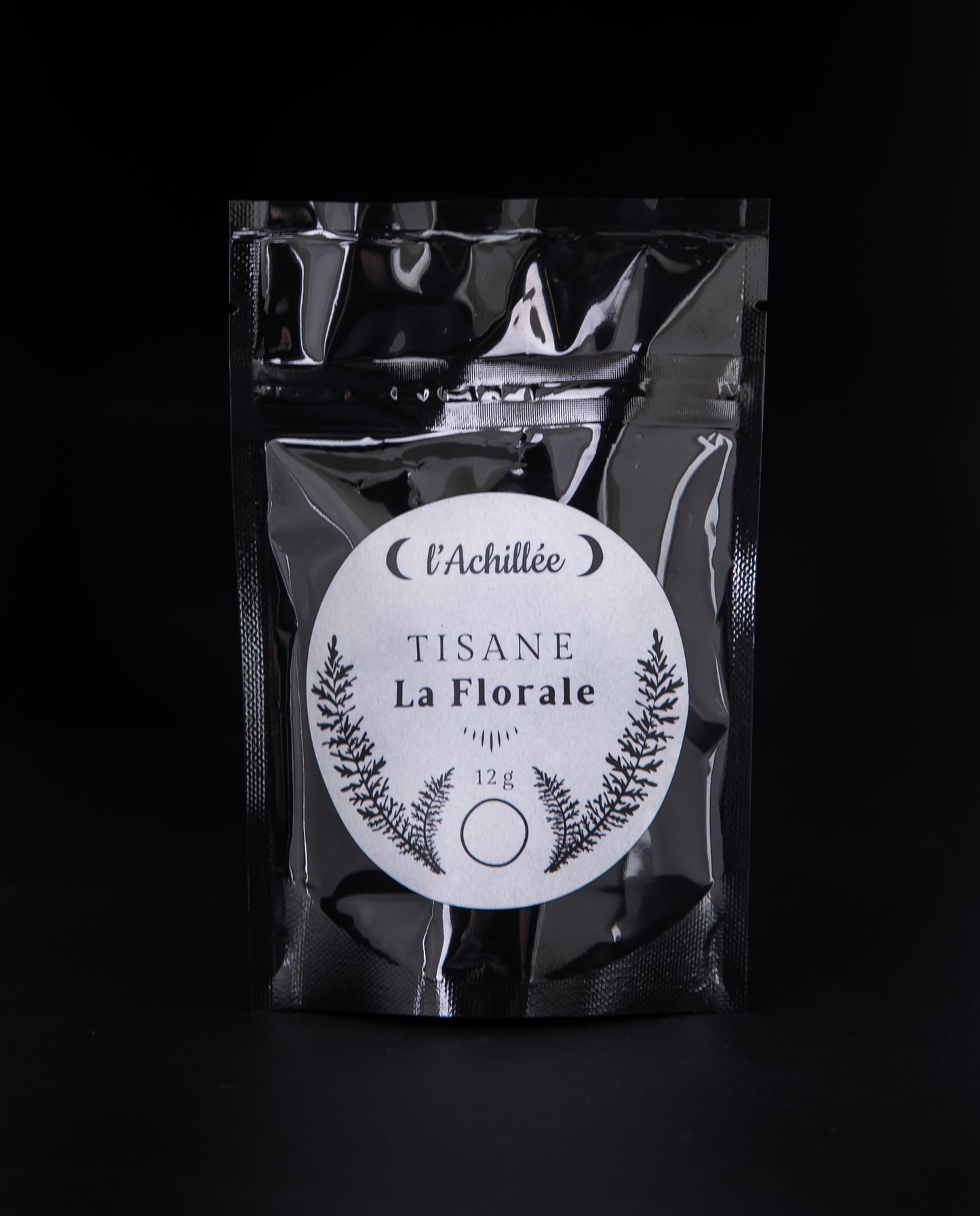 12g black bag of l'Achillée's "La Florale" tea on a black background