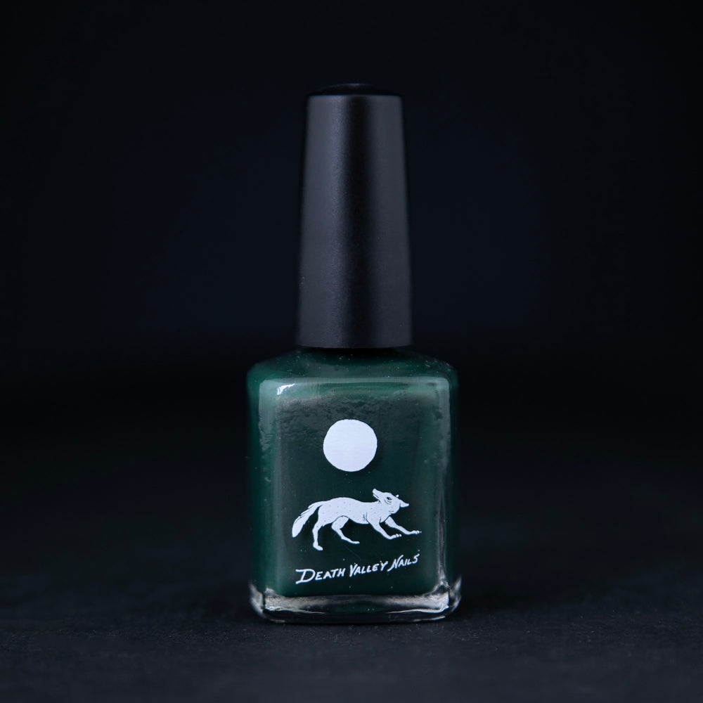 "Lone Pine" nail polish by Death Valley Nails on black background. The polish is forest green with a subtle copper shimmer.