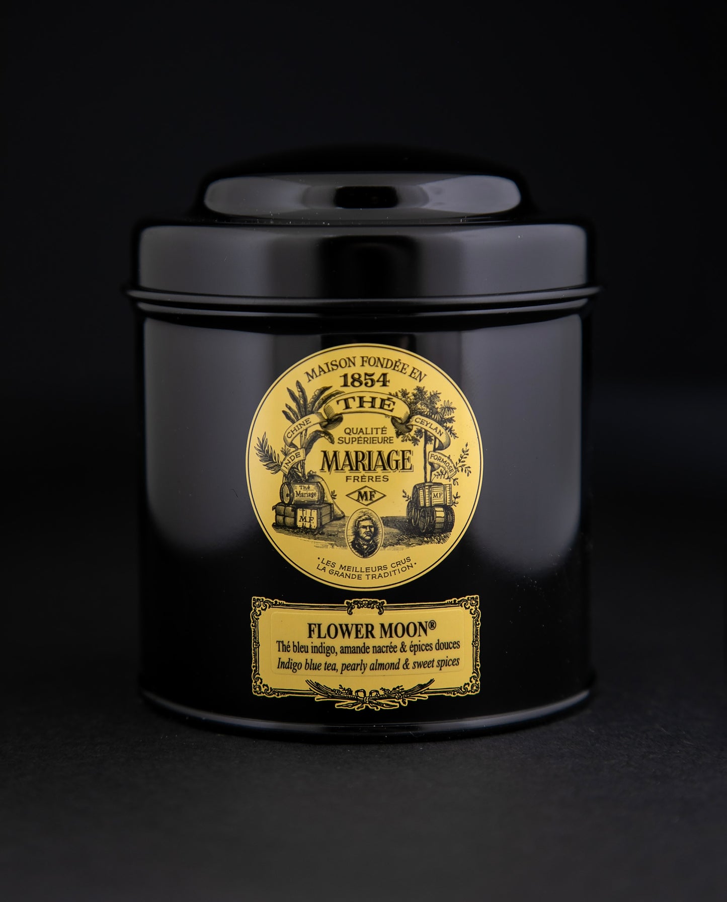 100g black laquered metal canister of Mariage Frère's "Flower Moon" tea blend on black background.