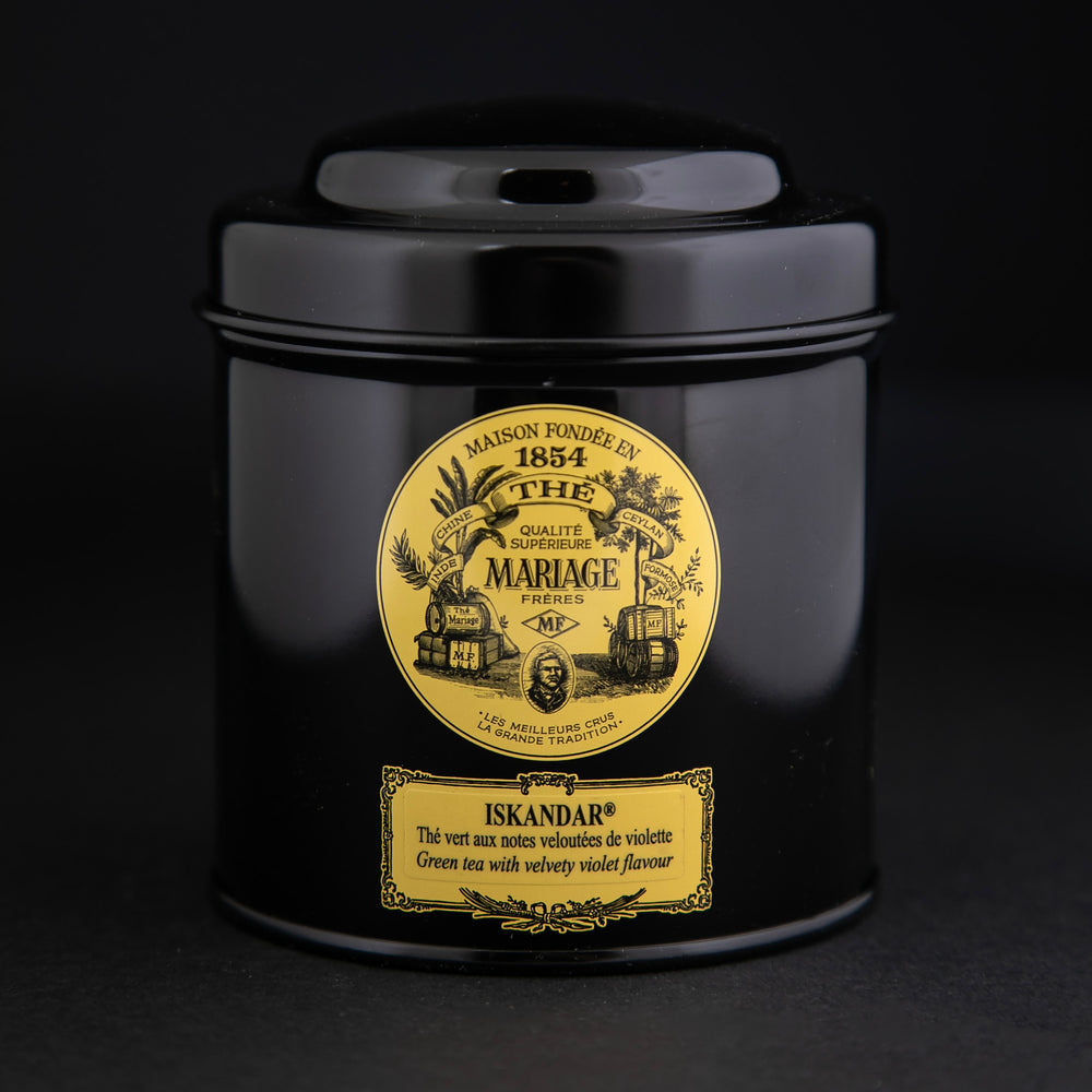 100g black laquered metal canister of Mariage Frère's "Iskandar" tea blend on black background.