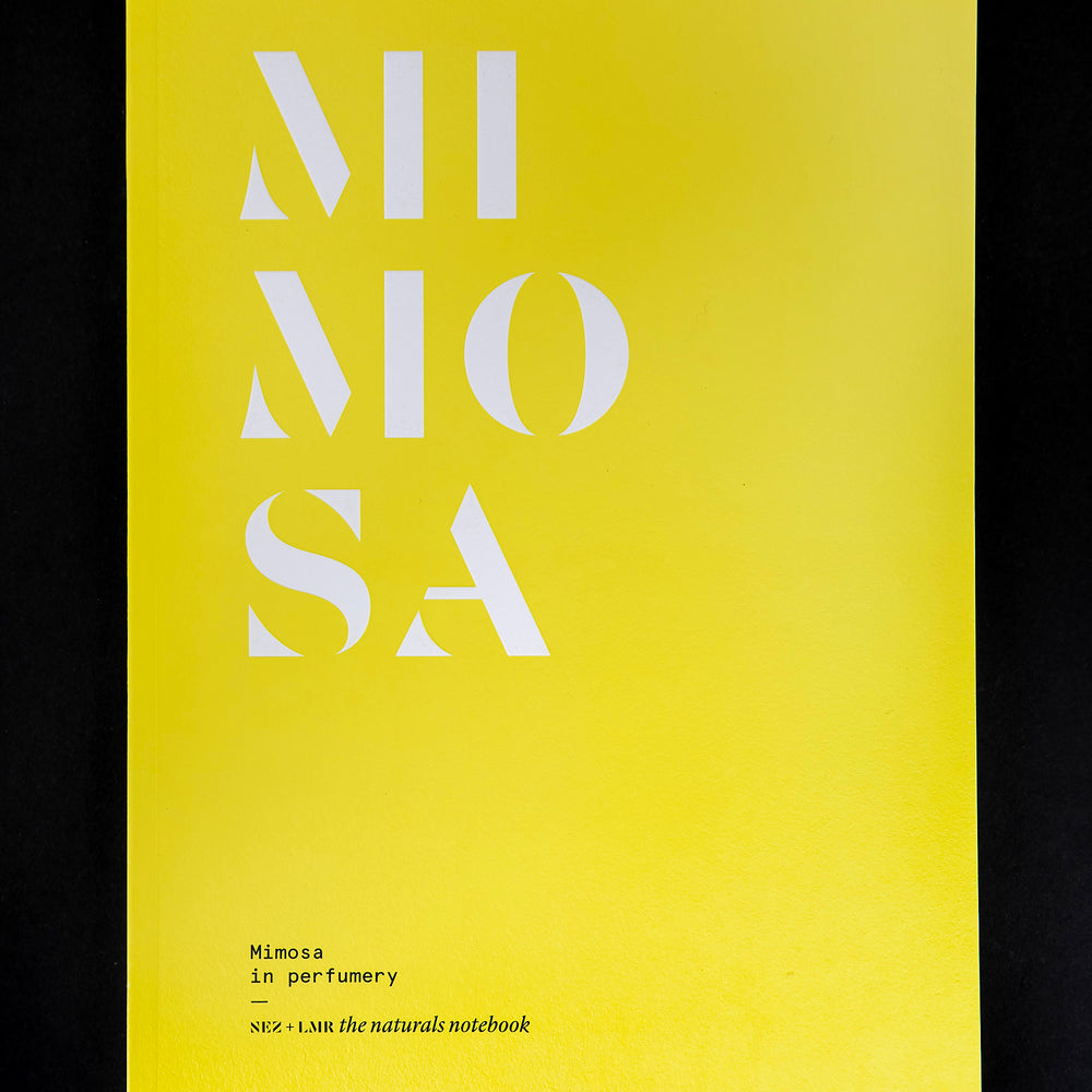 "Mimosa in Perfumery" book on black background. The cover is bright yellow and reads "MIMOSA" in bold white letters