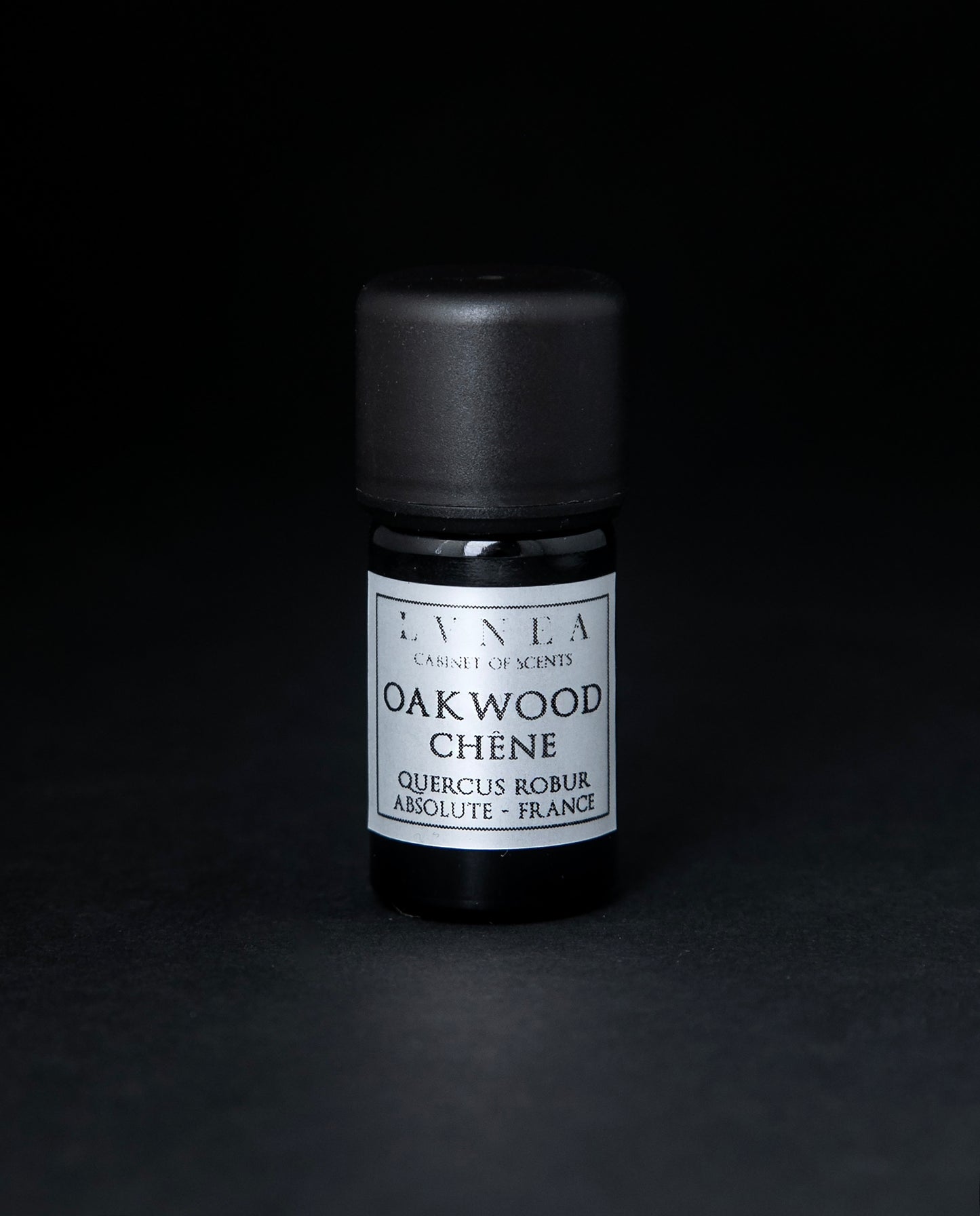 5ml black glass bottle of LVNEA's oakwood absolute on black background. The label on the bottle is silver.