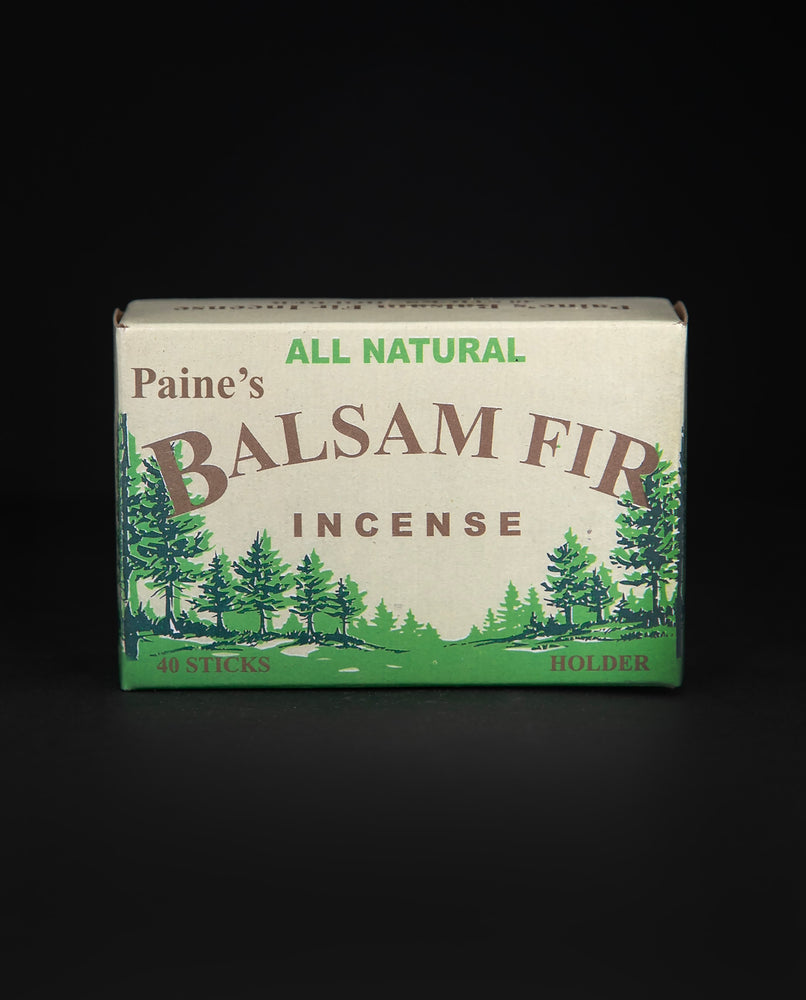 Closed box of Paine's Balsam Fir incense on black background. The box is tan, brown, and green, with illustrations of balsam fir trees on it