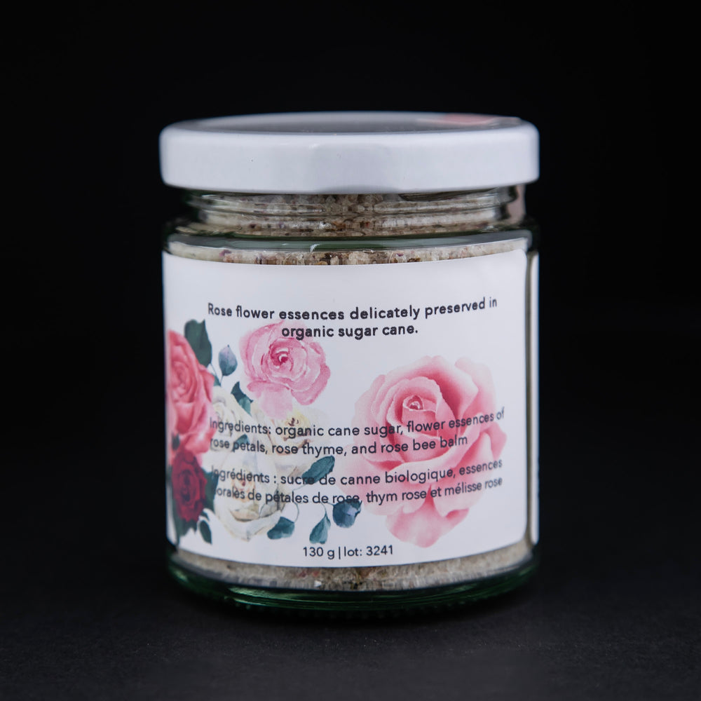 Back label of 130g clear glass jar of The New New Age's "Rose Flower Essences in Sugar". There are illustrations of roses on the label.