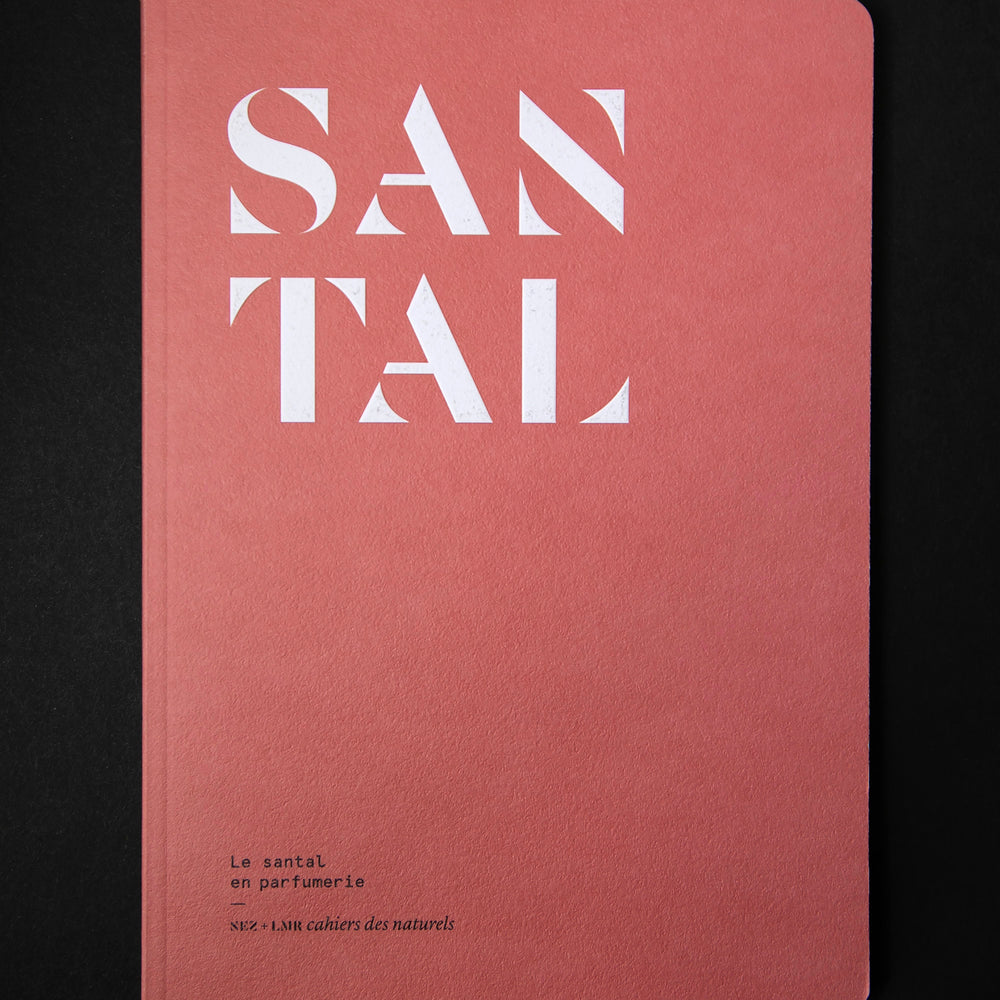 The book "Le santal en parfumerie" on black background. The cover is brick red and reads "SANTAL" in bold white graphic lettering.