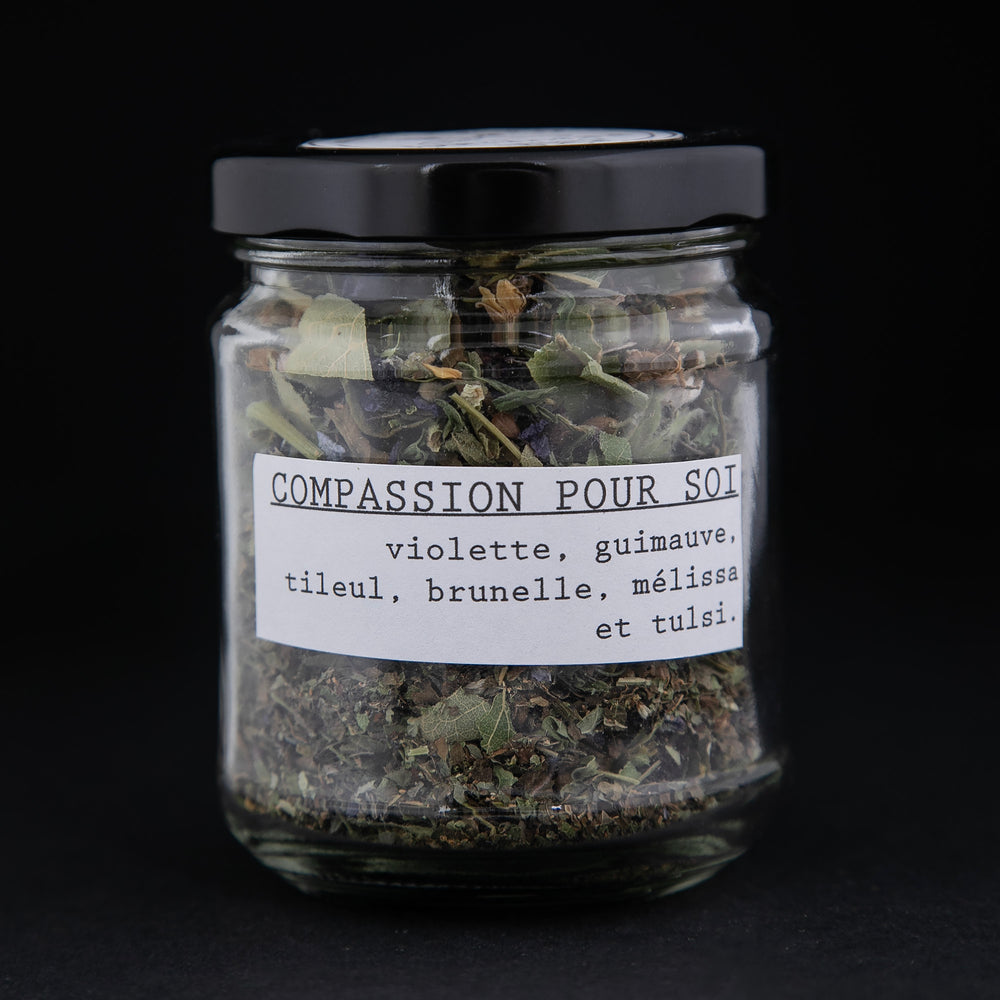 
                      
                        Clear glass jar of Blueberryjams' "Self Compassion" herbal tea blend against black background, french label is visible and reads "Compassion pour soi"
                      
                    