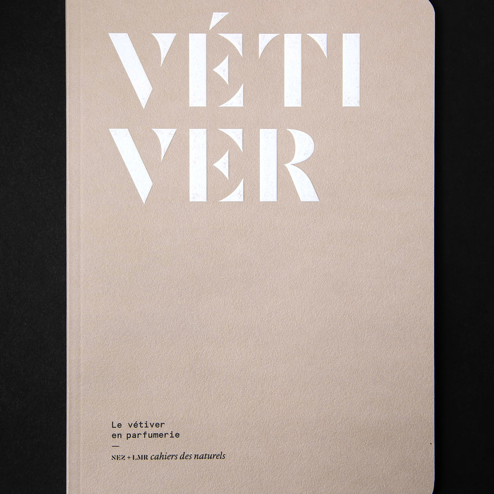 The book "Le vétiver en parfumerie" on black background. The cover is light brown and reads "VÉTIVER" in bold white graphic lettering.